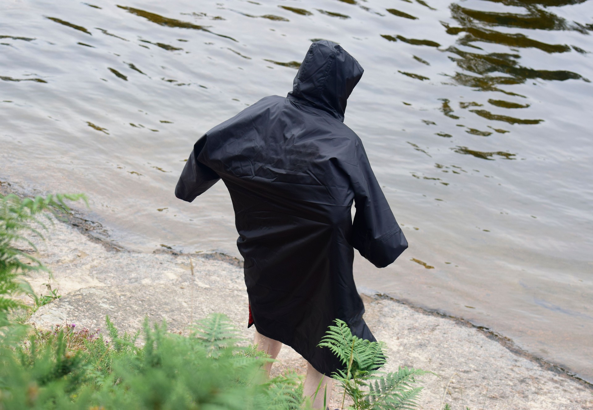 Man in dry changing robe after wild swim outdoors